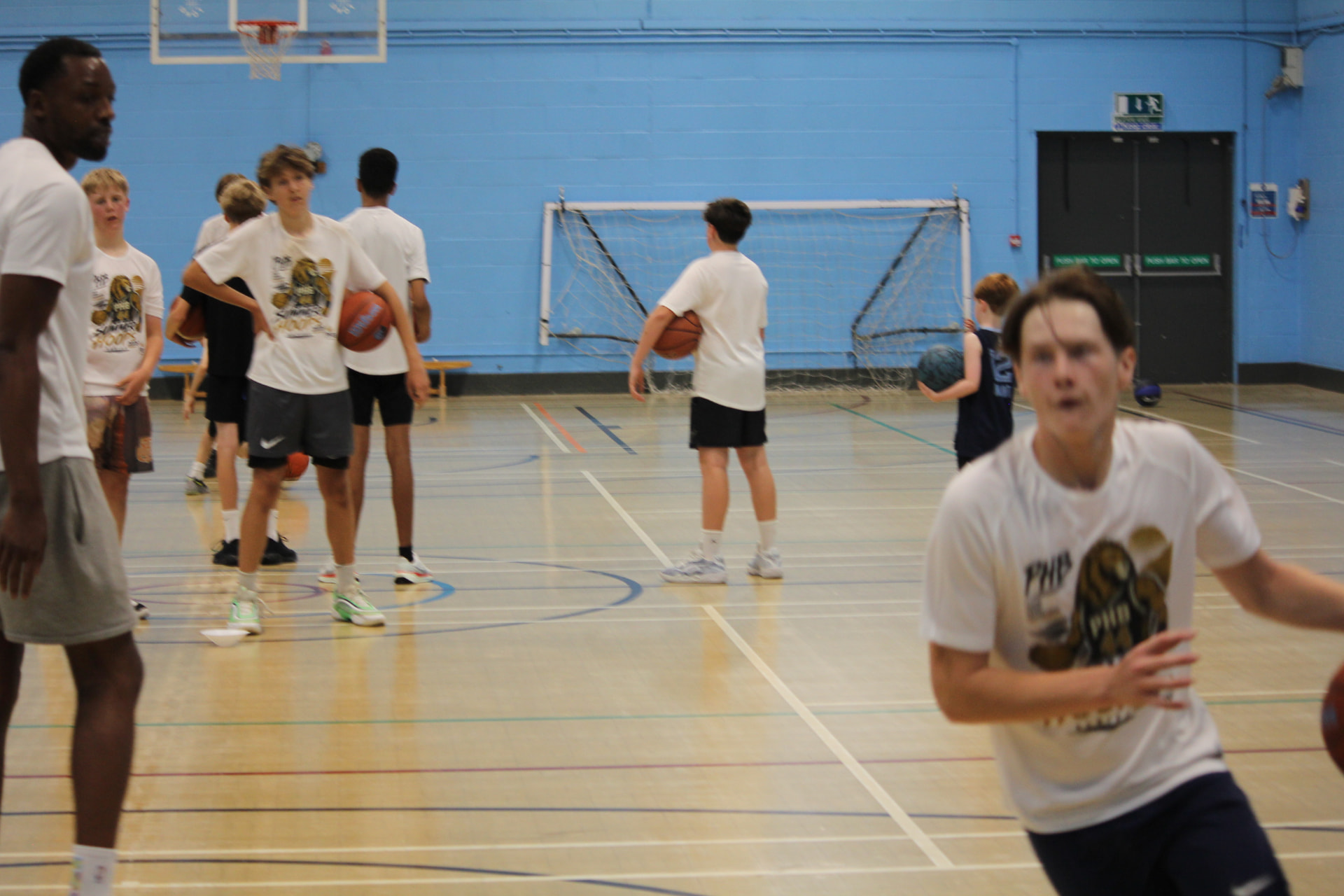 Coach Shane leading a Pro Hoops Blueprint basketball session with young people in a sports hall